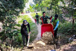 TMMD Ke-129 Bangun Jalan Lingkungan di Cibarusah, Akses Sulit Jadi Prioritas Pembangunan Kabupaten Bekasi — Satgas TNI Manunggal Membangun Desa (TMMD) Ke-129 Kodim 0509/Kabupaten Bekasi terus mempercepat pembangunan infrastruktur di Desa Wibawamulya, Kecamatan Cibarusah. Salah satu sasaran fisik yang tengah dikerjakan adalah pembangunan jalan lingkungan di Dusun 1 Tegal Panjang RT 02/RW 01, Sabtu (18/7/2026). Pembangunan jalan tersebut dikerjakan oleh personel Satgas TMMD Ke-129 bersama masyarakat secara bergotong royong. Salah satu personel yang terlibat, Serda Vikri dari Yonif 843/PVY, mengatakan kondisi medan menuju lokasi cukup sulit, namun tidak mengurangi semangat personel dalam menyelesaikan pekerjaan. "Meski akses menuju lokasi cukup sulit, ini merupakan bagian dari sasaran prioritas pembangunan fisik TMMD. Kami ingin jalan lingkungan ini dapat mempermudah masyarakat Desa Wibawamulya dalam menjalankan aktivitas sehari-hari," ujar Serda Vikri. Jalan lingkungan yang dibangun memiliki panjang 175 meter, lebar 1 meter, dan tebal 15 sentimeter. Infrastruktur tersebut diharapkan mampu meningkatkan aksesibilitas warga, memperlancar mobilitas, sekaligus mendukung aktivitas sosial dan perekonomian masyarakat setempat. Komandan Satgas TMMD Ke-129 Kodim 0509/Kabupaten Bekasi, Letkol Inf Michael Ronald S.I.P, mengatakan pembangunan infrastruktur di wilayah pedesaan menjadi salah satu fokus program TMMD sebagai bentuk sinergi TNI dengan pemerintah daerah dan masyarakat. "Pembangunan jalan lingkungan ini menjadi salah satu upaya meningkatkan kualitas infrastruktur desa agar manfaatnya benar-benar dirasakan masyarakat. Melalui TMMD, TNI bersama pemerintah daerah dan warga terus bersinergi membangun desa yang lebih maju dan sejahtera," kata Michael Ronald. Program TMMD Ke-129 di Desa Wibawamulya tidak hanya berfokus pada pembangunan fisik, tetapi juga mendorong tumbuhnya semangat gotong royong antara TNI dan masyarakat. Kehadiran program tersebut diharapkan mampu mempercepat pemerataan pembangunan sekaligus meningkatkan kesejahteraan warga di wilayah pedesaan. (Pendim 0509Kabupaten Bekasi)
